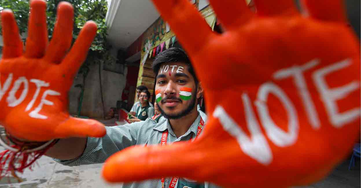 PTI04_18_2024_000240A School students with their faces and hands painted with words to encourage people to vote, pose for photographs ahead of the Lok Sabha elections, in Jammu, Thursday, April 18, 2024. Photo: PTI