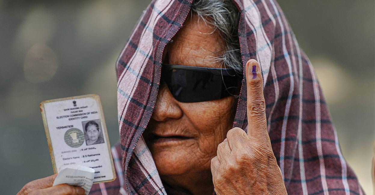 An elderly woman shows her finger marked with indelible ink and ID card after casting vote for the 2nd phase of Lok Sabha elections, in Bengaluru, Friday, April 26, 2024.