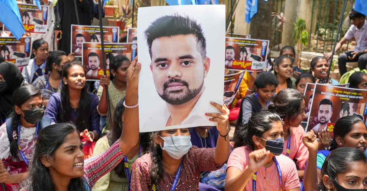 NSUI members hold a poster of JD(S) MP Prajwal Revanna during a protest against his involvement in the alleged sexual abuse case, in Bengaluru, Tuesday, April 30, 2024. Photo: PTI