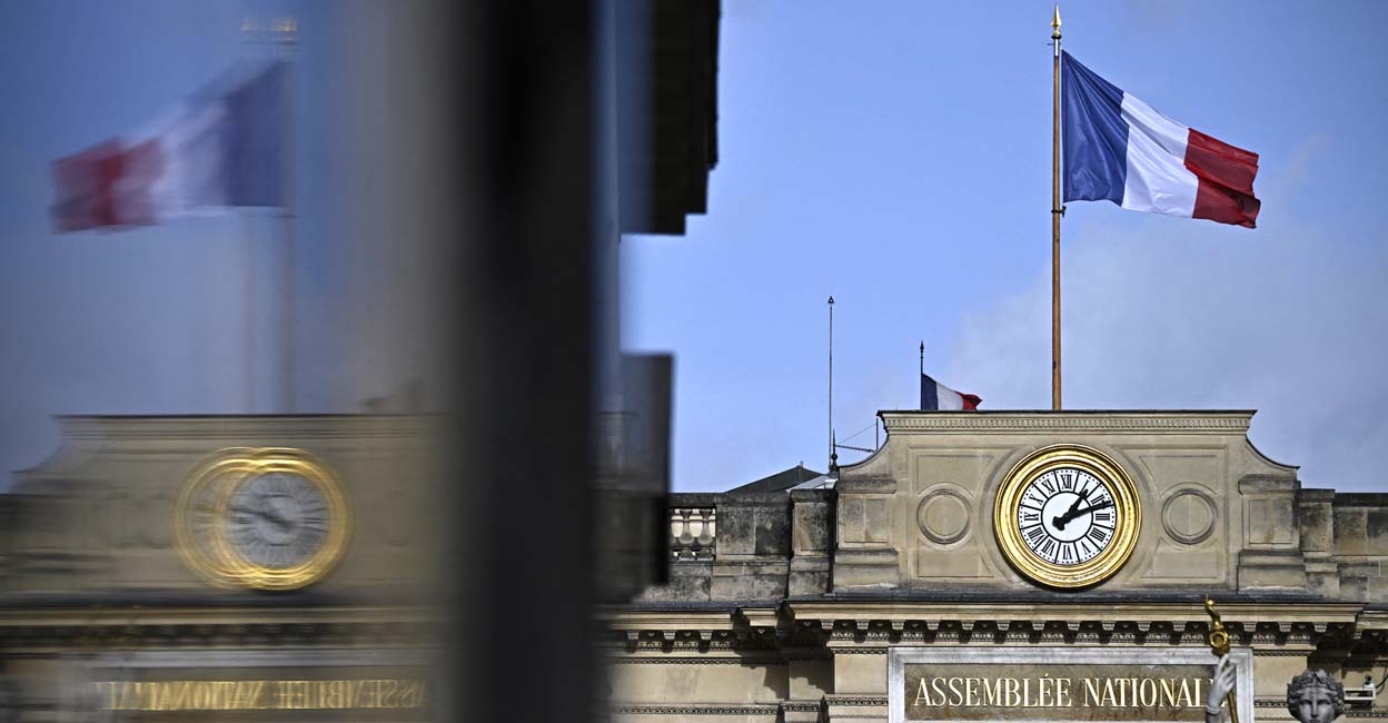 FRANCE-POLITICS-GOVERNMENT-ASSEMBLY This photograph taken on January 24, 2024 shows the French flag at the entrance of the French National Assembly in Paris, seen from the Place du Palais Bourbon. (Photo by JULIEN DE ROSA / AFP)