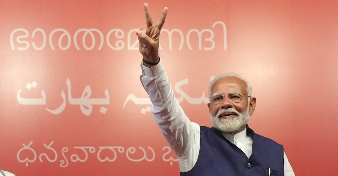 Prime Minister Narendra Modi greets party workers at BJP headquarters in New Delhi on Tuesday evening. 'Thank you, Bharath' in various Indian languages, including Malayalam, can be seen in the background. Photo: PTI 