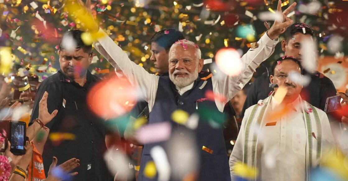 Prime Minister Narendra Modi greets party workers upon his arrival for a meeting at the party headquarters after winning the polls. Photo: PTI