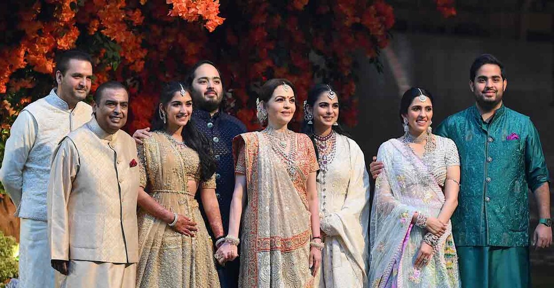 Indian billionaire Mukesh Ambani (2L) along with his wife Nita (4R) pose with their elder son Akash (R) his wife Shloka (2R), daughter Isha (3R) her husband Anand Piramal (L) and younger son Anant (4L) his fiancée Radhika Merchant (3L) during Anant's engagement ceremony in Mumbai on January 19, 2023. Photo: Sujit Jaiswal / AFP