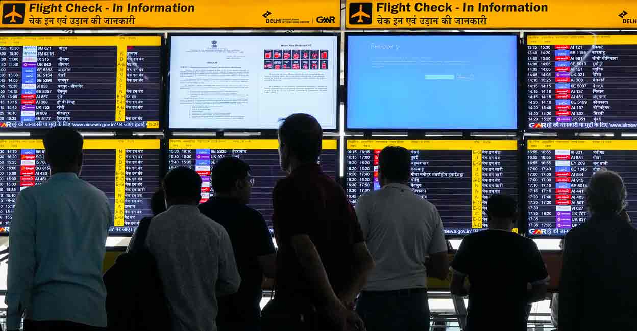 Passengers look at screens, one of them showing Blue Screen error, at T3 Terminal of the Indira Gandhi International Airport amid Microsoft outage, in New Delhi, Friday, July 19, 2024. Photo: PTI