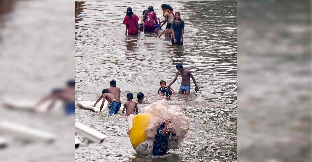 PTI07_08_2024_000063A People make their way through a waterlogged street following rains, in Mumbai, Monday, July 8, 2024. Photo: PTI