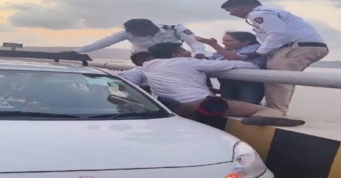 mumbai-bridge-accident A woman, who was on the verge of falling into the sea from Atal Setu, being saved by a cab driver and police personnel, in Mumbai on Friday evening. Photo: PTI