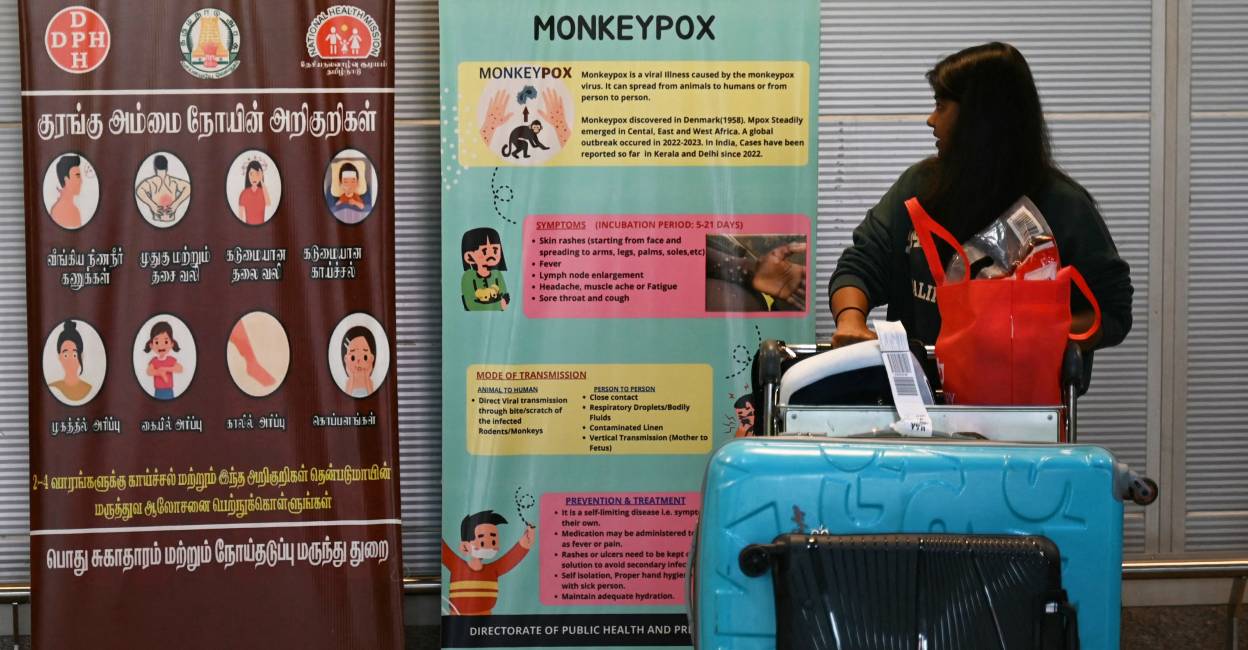 A passenger walks past the mpox awareness banners at Anna International Airport terminal in Chennai . Photo: AFP