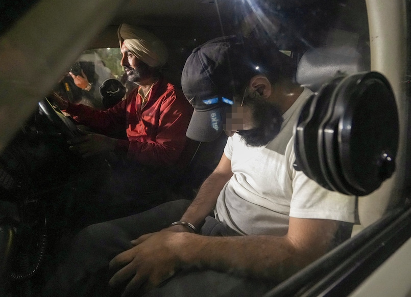 Indians deported from the US being escorted by the police as they leave the airport upon their arrival in Amritsar. Photo: PTI