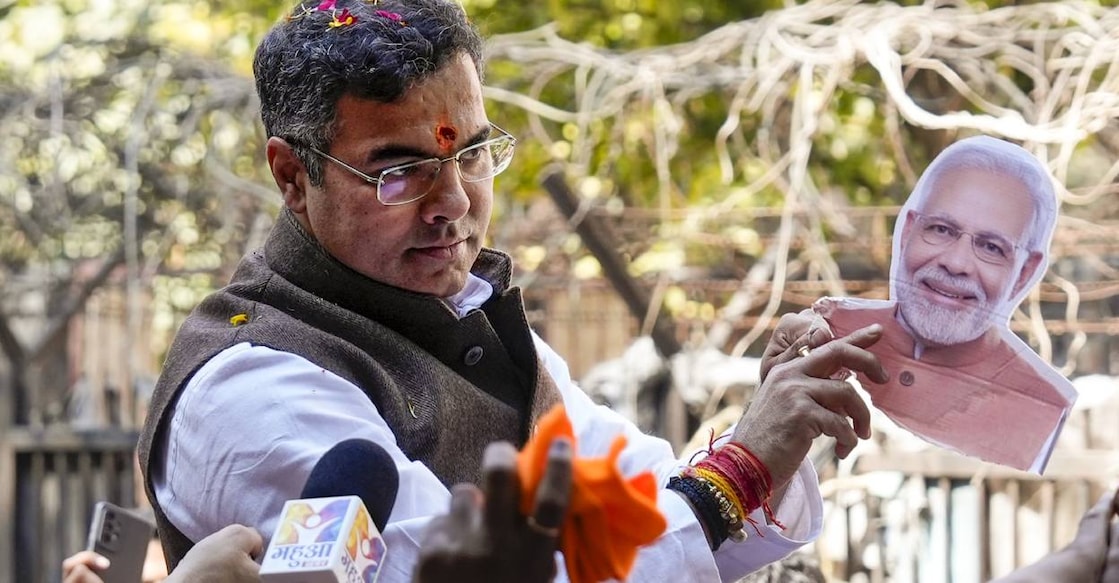 BJP candidate from New Delhi assembly constituency Parvesh Verma holds a portrait of Prime Minister Narendra Modi amid celebration outside a counting center after claiming victory in the Delhi Assembly polls during the counting of votes, in New Delhi. Photo: PTI