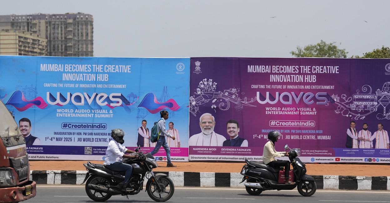 waves-summit-mumbai Commuters pass by hoardings put up for the World Audio Visual & Entertainment Summit (WAVES 2025), in Mumbai. Photo: PTI