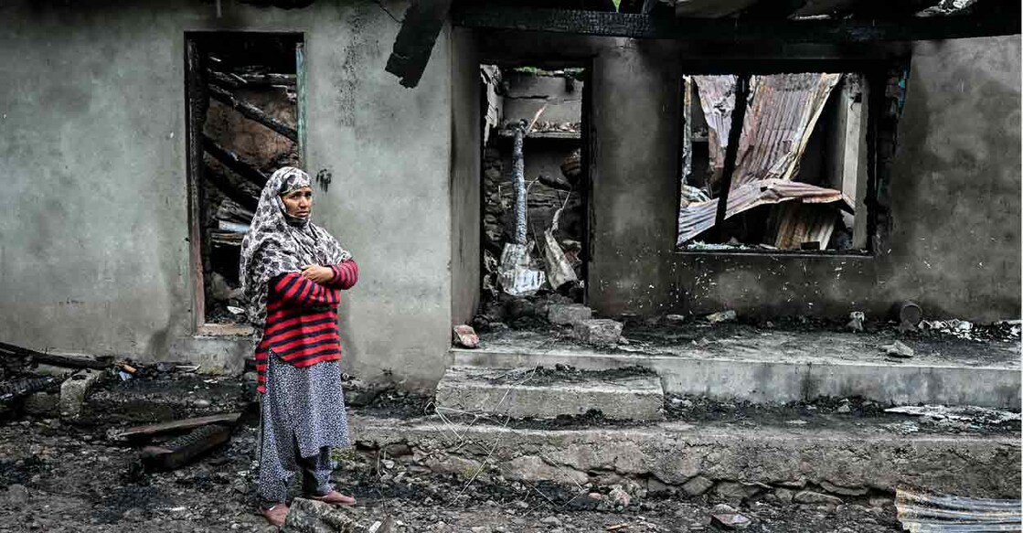 A woman stands outside a house destroyed by Pakistani artillery shelling at the Salamabad village in Uri, about 110kms from Srinagar, on May 8, 2025. Photo: AFP/ Sajjad Hussain