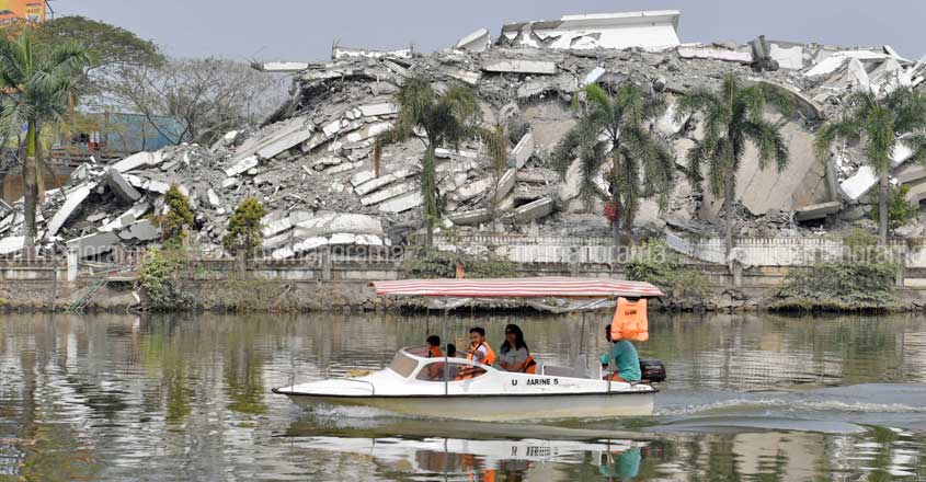 A man shows victory sign as he cruise through the canal near recently razed Holy Faith H2O appartments. Photo: Josekutty Panackal A man shows victory sign as he cruise through the canal near recently razed Holy Faith H2O appartments. Photo: Josekutty Panackal