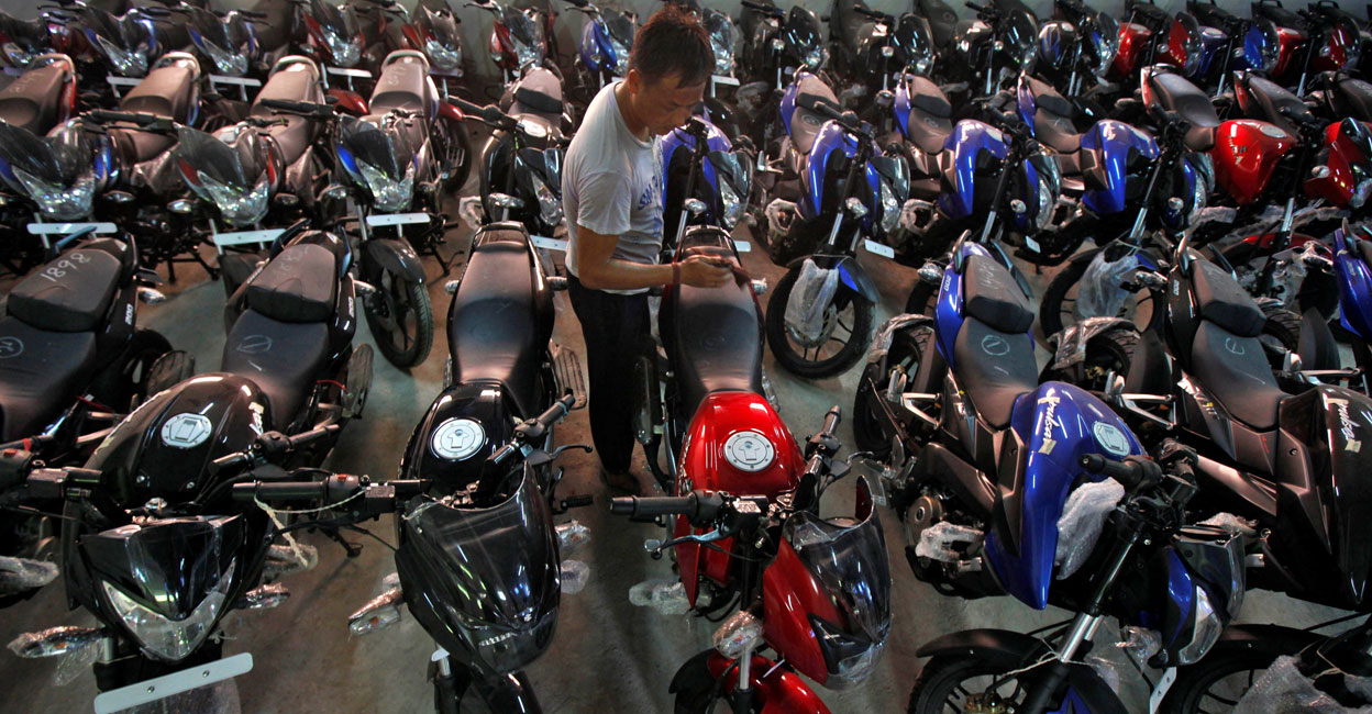 BAJAJ-AUTO-BUYBACK A worker cleans a motorcycle at a Bajaj showroom in Kolkata on October 16, 2013. File photo: Reuters/Rupak De Chowdhuri