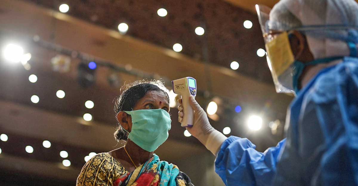 A medic checks the temperature of a sanitation worker during a free health checkup camp, amid the nationwide COVID-19 lockdown, at Tummalapalli Kalakshetram in Vijayawada, Saturday, June 6, 2020. (PTI Photo)
