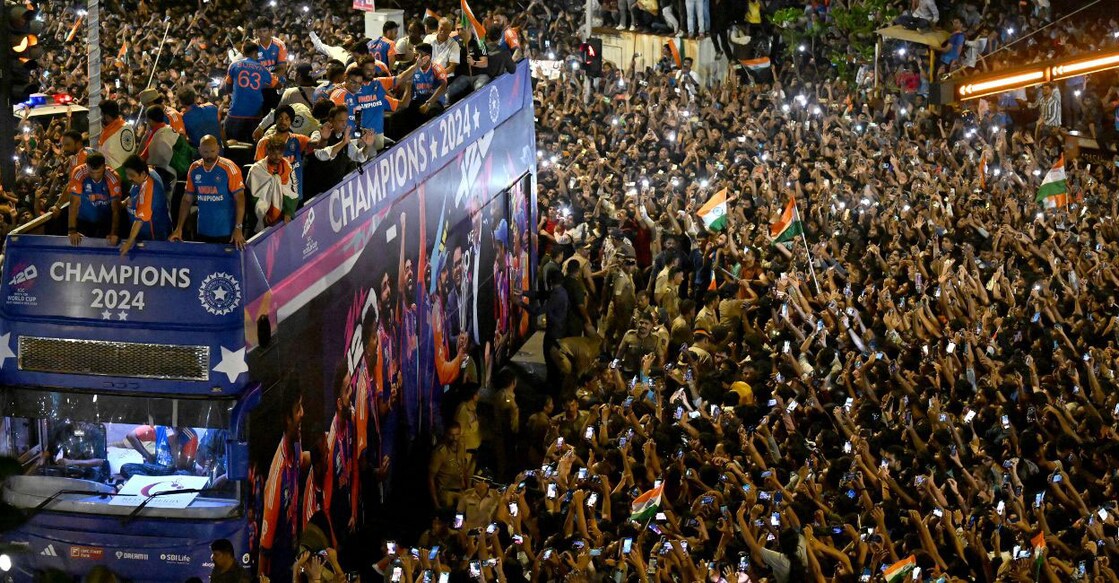 Indian cricketers gesture during an open bus parade in Mumbai on Thursday. Photo: AFP/ Punit Paranjpe