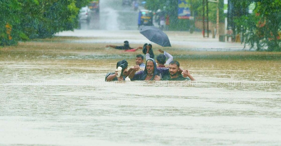 Volunteers rescue a man from flood-affected area in Pala in Kottayam district.
