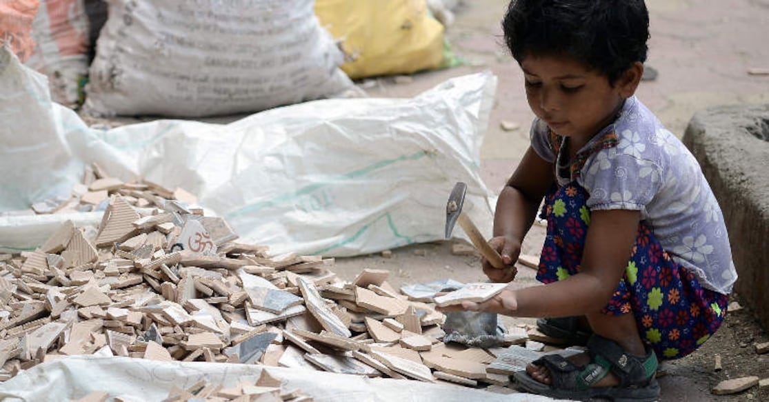 Child Labour An Indian child (R) breaks apart broken tiles alongside her mother outside an under-construction apartment building in Mumbai on June 1, 2015. India's government moved last month to toughen child labour laws in a country where millions of youngsters work long hours, often in poor conditions, but activists slammed the steps as inadequate. The current law prohibits children under 14 from working only in hazardous jobs, although even this is not properly implemented, according to activists. AFP PHOTO/ Indranil MUKHERJEE