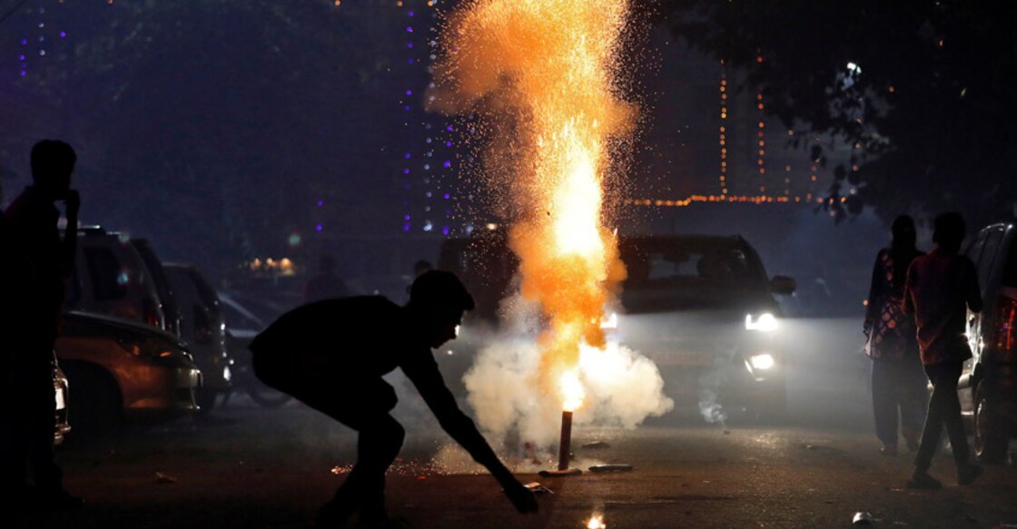 A boy lights a firecracker on a street as he celebrates Diwali in New Delhi on Wednesday. Photo: Reuters