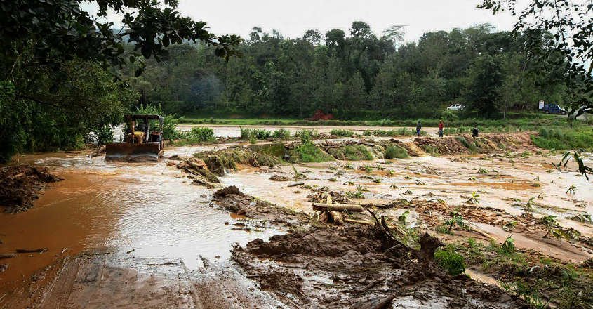 Kodagu An earth-mover clears the sludge from a road in the flood-hit Madapur village of Kadagu district, Karnataka. PTI