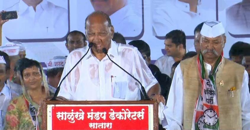 Pune: NCP President Sharad Pawar addresses in pouring rain at an election rally in Pune on Oct 18, 2019. (Photo: IANS)