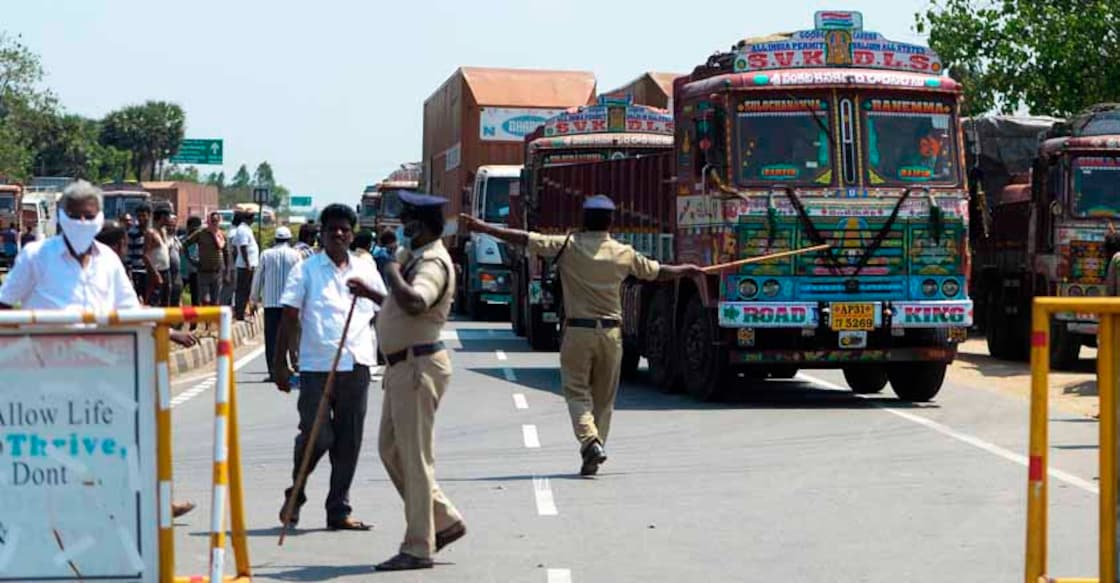 Health officials an policemen stop vehicles at the Tamil Nadu-Andra Pradesh interstate border during a government-imposed lockdown as a preventive measure against the COVID-19 coronavirus, on outskirts of Chennai on March 24, 2020. (Photo by Arun SANKAR / AFP)