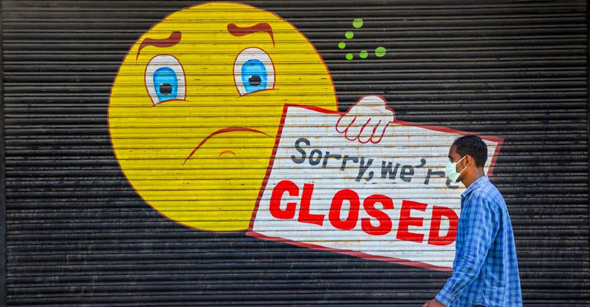 A man wearing a protective mask walks in front of a closed shop during the nationwide lockdown, imposed in wake of the coronavirus pandemic, in Amritsar, Thursday. Photo: PTI