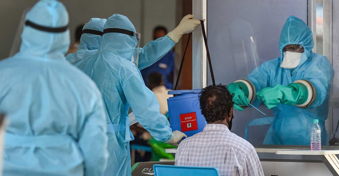 A medic takes samples from an Indian national arriving from Myanmar at Anna International Airport, during the ongoing COVID-19 nationwide lockdown, in Chennai. Photo: PTI