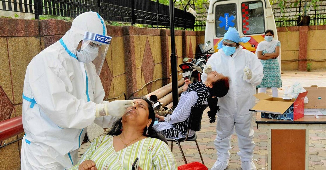Medics wearing PPE kits collect samples of people for COVID-19 test at a center, during the ongoing nationwide lockdown, in New Delhi, Tuesday, June 23, 2020. (PTI Photo)