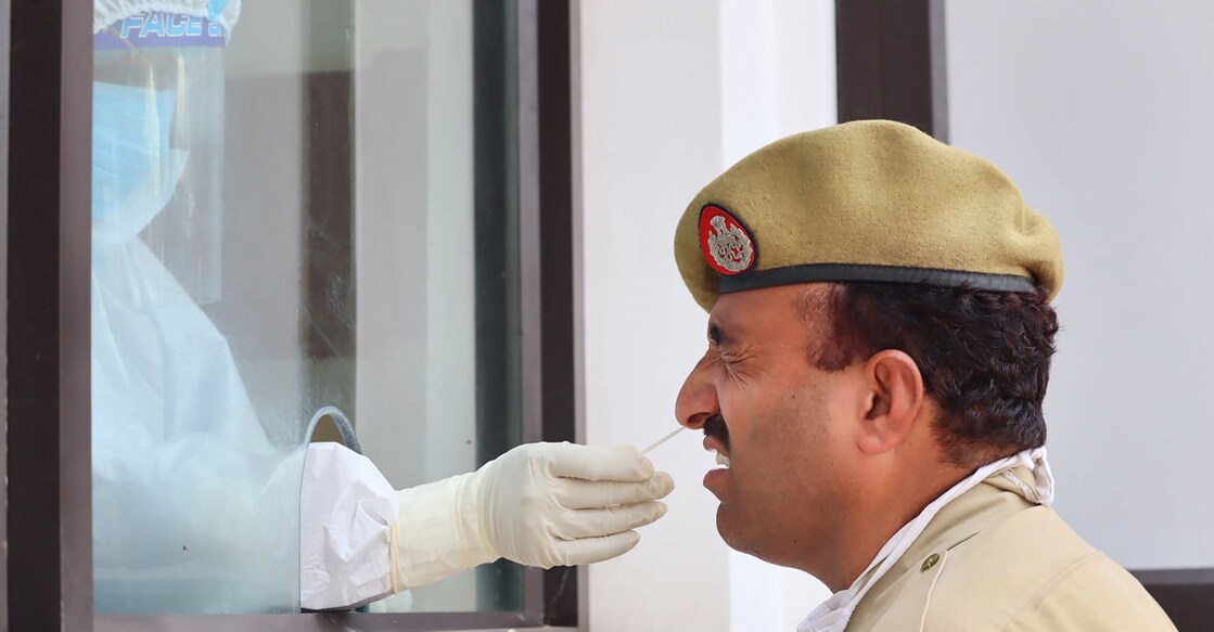 A health worker collects a sample from a police constable for COVID-19 test, during Unlock 2.0, at SDH Mendhar in Poonch district, Friday, July 24, 2020. (PTI Photo)
