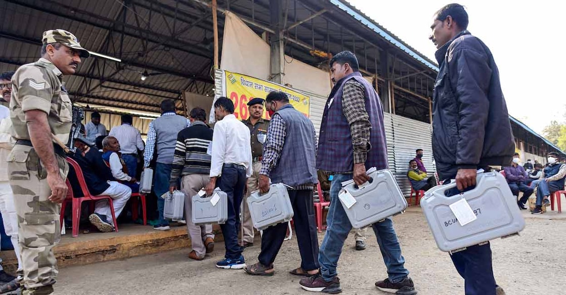 Polling officials carry electronic voting machines during counting day of Uttar Pradesh Assembly elections, at a counting centre in Prayagraj district, Thursday, March 10, 2022. (PTI Photo)