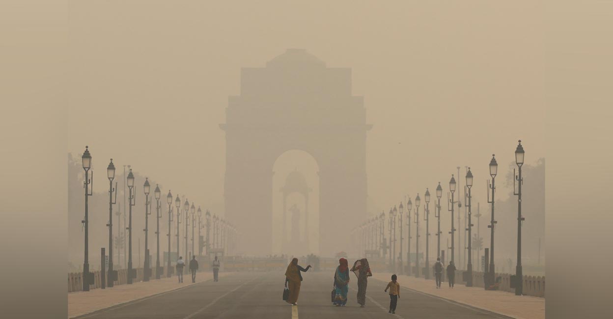 Women walk on a road near India Gate as the sky is enveloped with smog after Delhi's air quality worsened due to air pollution, in New Delhi, India, November 19, 2024. REUTERS/Anushree Fadnavis