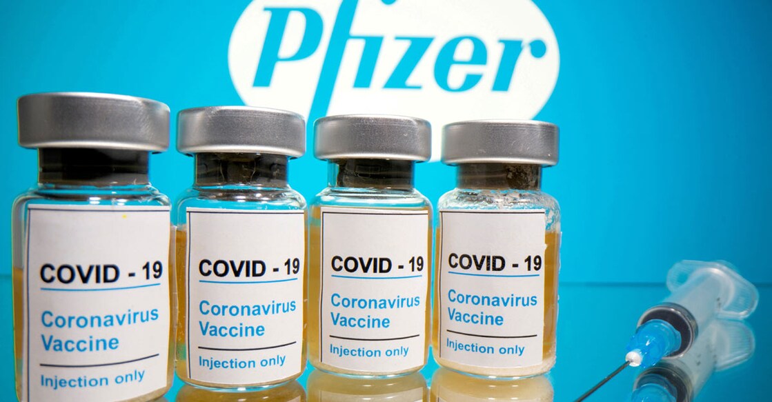 Vials with a sticker reading, "COVID-19 / Coronavirus vaccine / Injection only" and a medical syringe are seen in front of a displayed Pfizer logo in this illustration taken October 31, 2020. REUTERS/Dado Ruvic/File Photo
