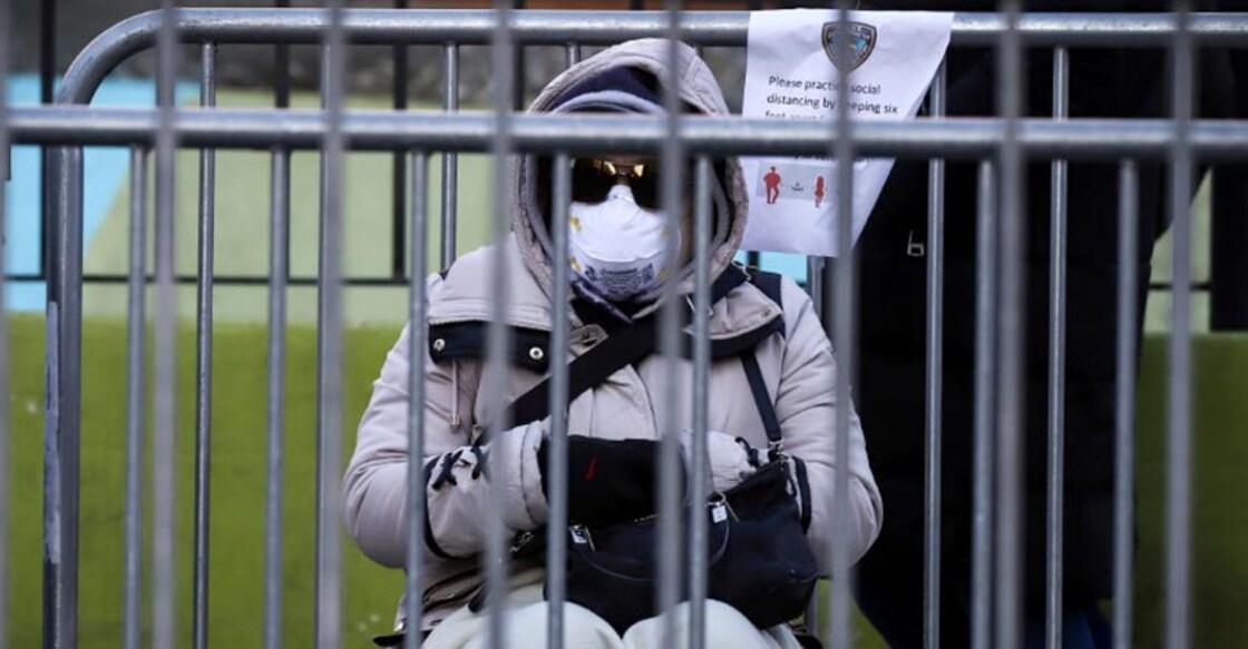A person waits in line to be tested for coronavirus disease (COVID-19) while wearing protective gear, outside Elmhurst Hospital Center in the Queens borough of New York City, U.S., March 26, 2020.  REUTERS/Stefan Jeremiah