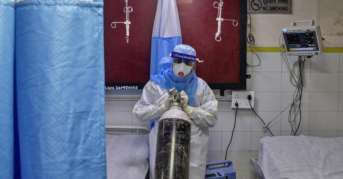 FILE PHOTO:  A medical worker wearing personal protective equipment (PPE) pushes an oxygen cylinder for a patient suffering from the coronavirus disease (COVID-19) at the casualty ward in Lok Nayak Jai Prakash (LNJP) hospital, in New Delhi, India July 17, 2020. REUTERS/Danish Siddiqui/File photo