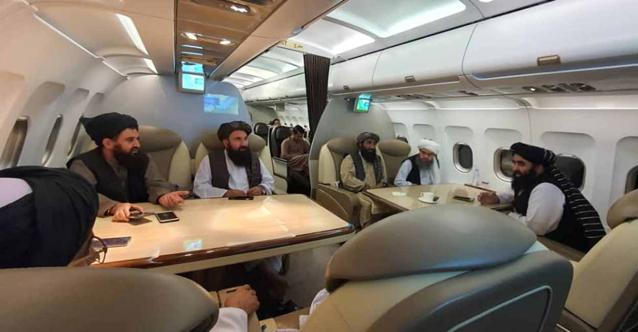 Taliban delegates are seated in a plane in an unidentified location, in this handout photo uploaded to social media on October 9, 2021. Picture uploaded on October 9, 2021. Social media handout/via Reuters