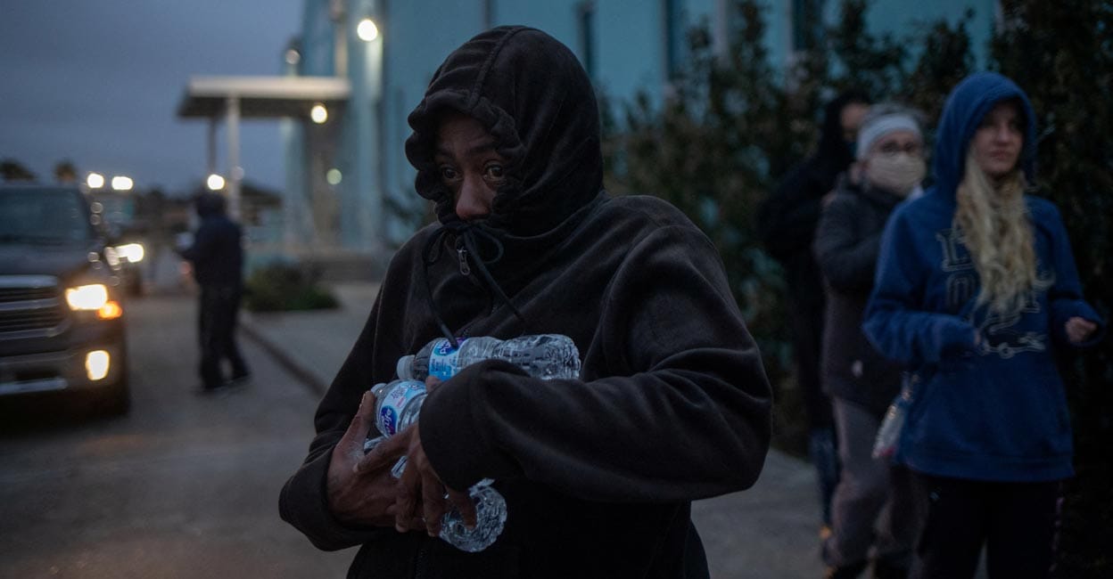 Texas blackout A woman carries bottled water she received from a warming center and shelter after record-breaking winter temperatures, as local media report most residents are without electricity, in Galveston, Texas, US, February 17, 2021. REUTERS/Adrees Latif