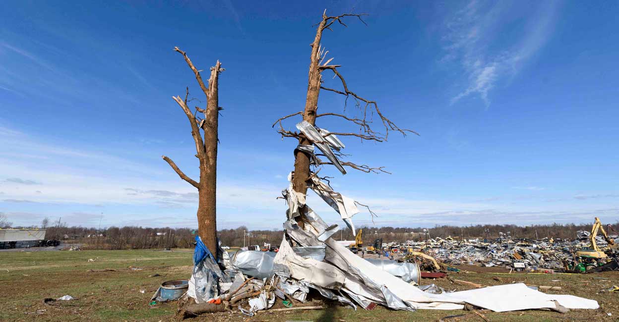 Debris is wrapped around danaged trees as emergency workers search through what is left of the Mayfield Consumer Products Candle Factory after it was destroyed by a tornado in Mayfield, Kentucky, on December 11, 2021. Photo: John Amis / AFP