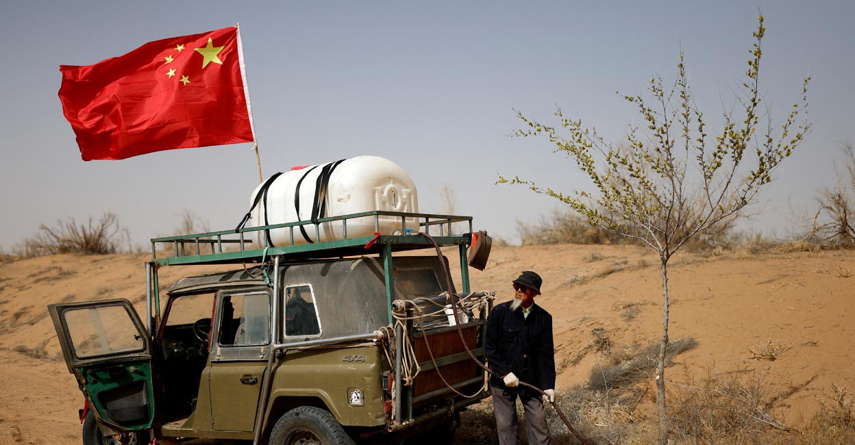 Wang Tianchang Wang Tianchang, 78, waters a tree planted on the edge of the Gobi desert on the outskirts of Wuwei, Gansu province, China, April 15, 2021. The Wangs have been fighting desertification since they settled on barren land near the village of Hongshui in Wuwei, a city in Gansu close to the border with Inner Mongolia, in 1980. A local institution in northwest China's Gansu province, Wang and his family lead busloads of young volunteers from the provincial capital of Lanzhou into the desert each year to plant and irrigate new trees and bushes. Photo: REUTERS/Carlos Garcia Rawlins