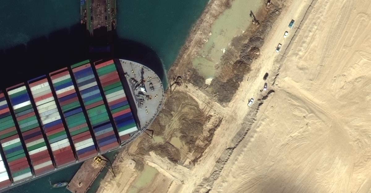 A view of the earth moving equipment excavating sand near the bow of the Ever Given container ship in Suez Canal
