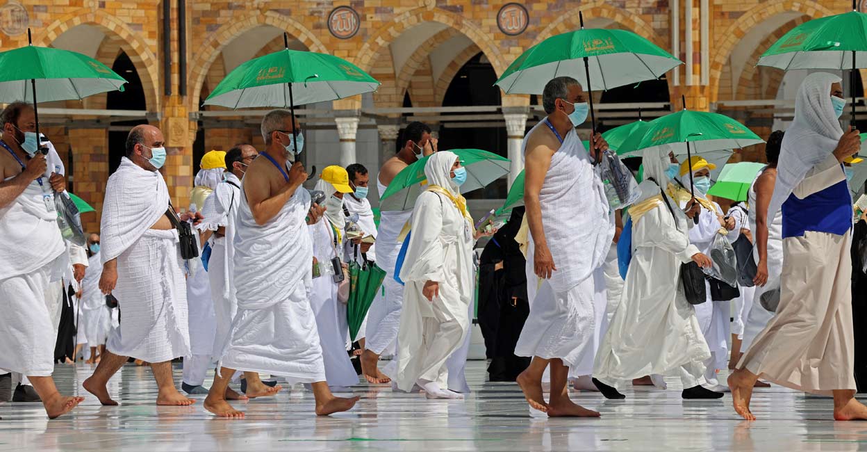 Muslim pilgrims Pilgrims holding umrellas to protect themselves from the heat, arrive at the Kaaba, Islam's holiest shrine, at the Grand mosque in the holy city of Meccca, at the start of the Hajj season, on July 17, 2021. Photo by Fayez Nureldine / AFP