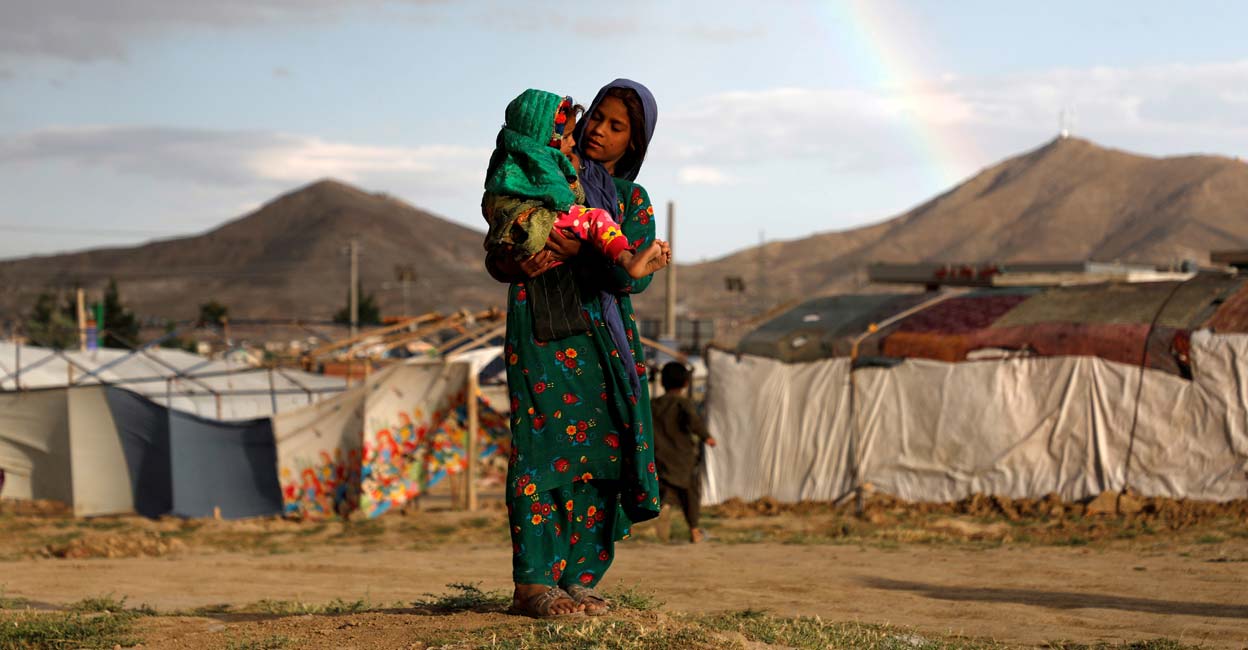 An internally displaced Afghan girl carries a child near their shelter An internally displaced Afghan girl carries a child near their shelter at a camp on the outskirts of Kabul, Afghanistan June 20, 2019. Photo: REUTERS/Omar Sobhani