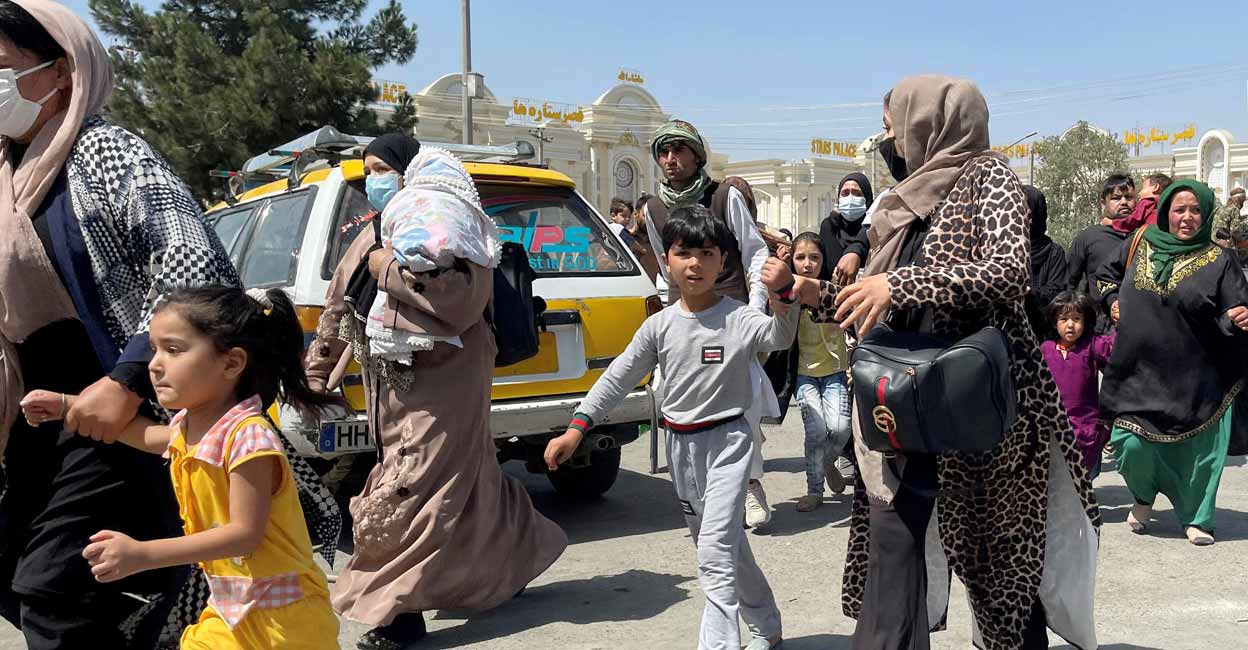 Women with their children try to get inside Hamid Karzai International Airport in Kabul, Afghanistan August 16, 2021. Reuters