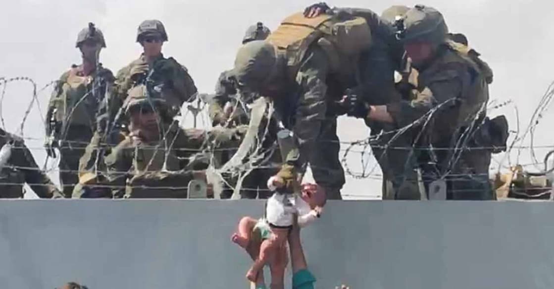 A baby is handed over to the American army over the perimeter wall of the airport for it to be evacuated, in Kabul, Afghanistan, August 19, 2021. Omar Haidari/Reuters