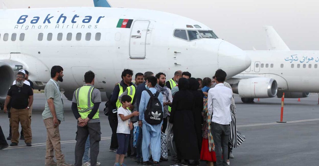 Dual-nationality passengers who have missed their flight for Qatar speak with an airport official at the international airport in Kabul, Afghanistan, September 9, 2021. WANA (West Asia News Agency) via REUTERS