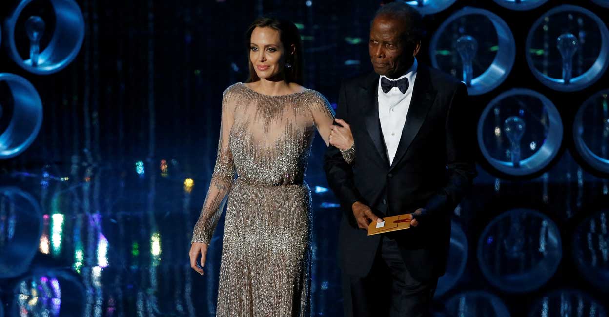 Angelina Jolie and Sidney Poitier Actors Angelina Jolie and Sidney Poitier take the stage to present the Oscar for achievement in directing at the 86th Academy Awards in Hollywood, California March 2, 2014. Reuters/Lucy Nicholson