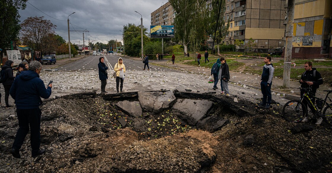 Local residents examine a crater following a missile strike in Dnipro on Monday, amid Russia's invasion of Ukraine. Photo: AFP/ Dimitar Dilkoff 