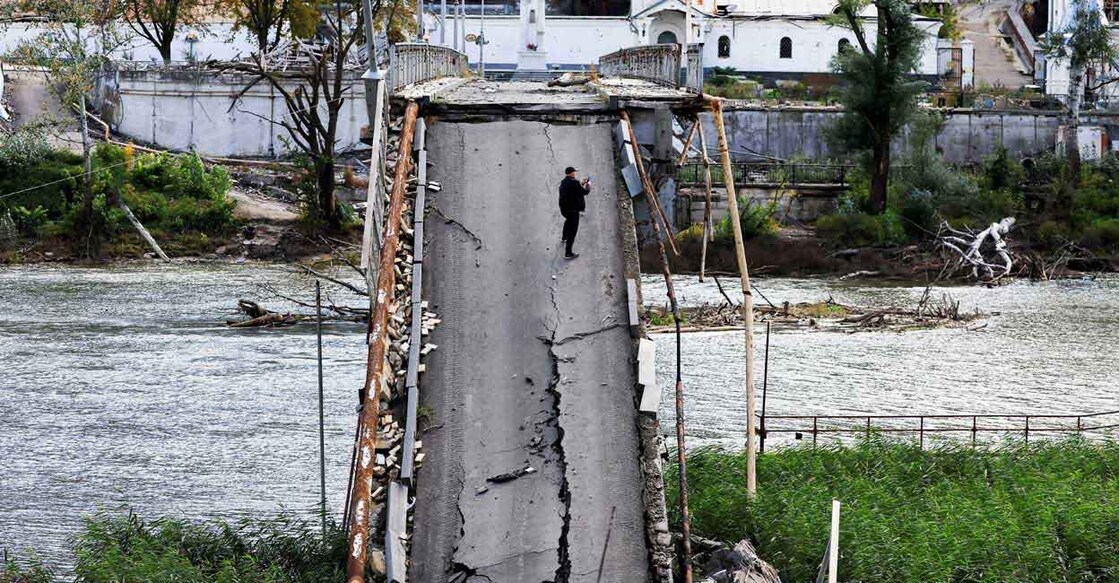 A man uses his mobile phone as he stands on a bridge destroyed by a Russian Missile strike, amid Russia's attack on Ukraine, in Svyatohirsk, in Donetsk region, Ukraine, October 3, 2022. Photo: REUTERS/Zohra Bensemra