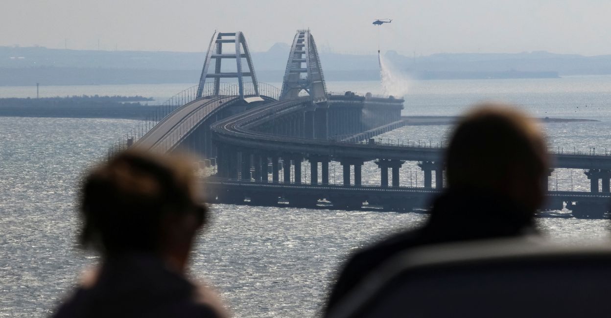 People watch fuel tanks ablaze on the Kerch bridge in the Kerch Strait, Crimea, October 8, 2022. Photo: Reuters