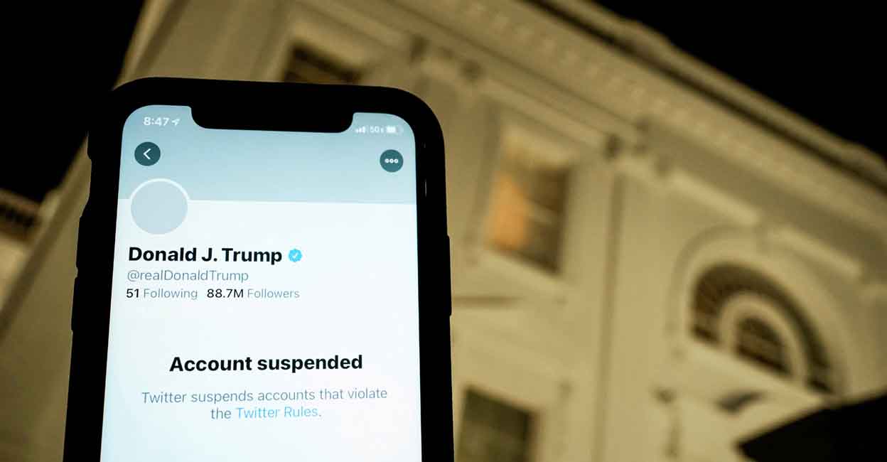 TWITTER-BANS A photo illustration shows the suspended Twitter account of U.S. President Donald Trump on a smartphone and a lit window in the White House residence in Washington, U.S., January 8, 2021. REUTERS/Joshua Roberts