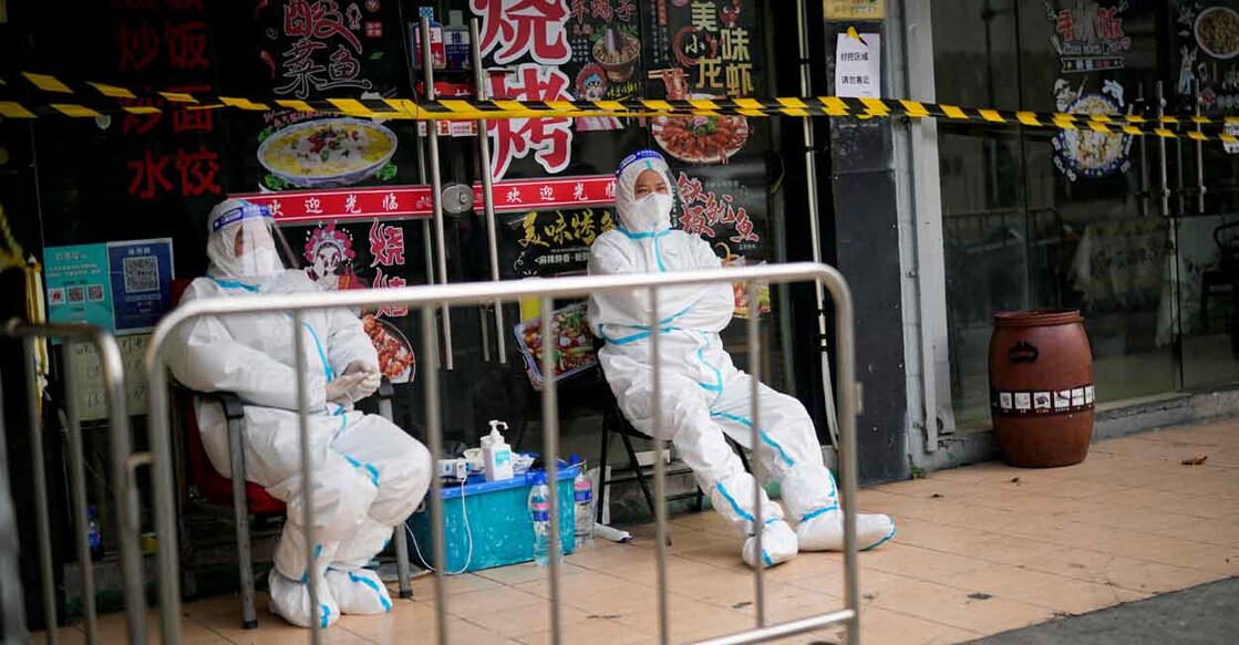Workers in protective suits keep watch behind a barrier at a sealed restaurant area, following the coronavirus disease (COVID-19) outbreak in Shanghai, China, November 26, 2022. Photo: REUTERS/Aly Song